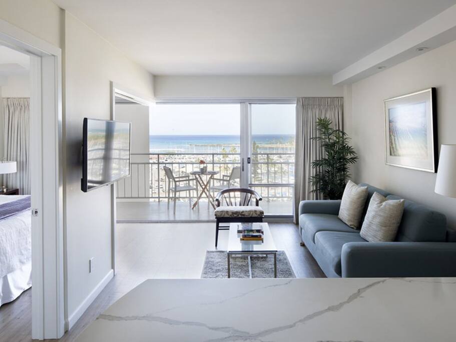 Relax in the living room with ample seating, a TV, and lots of sunlight!