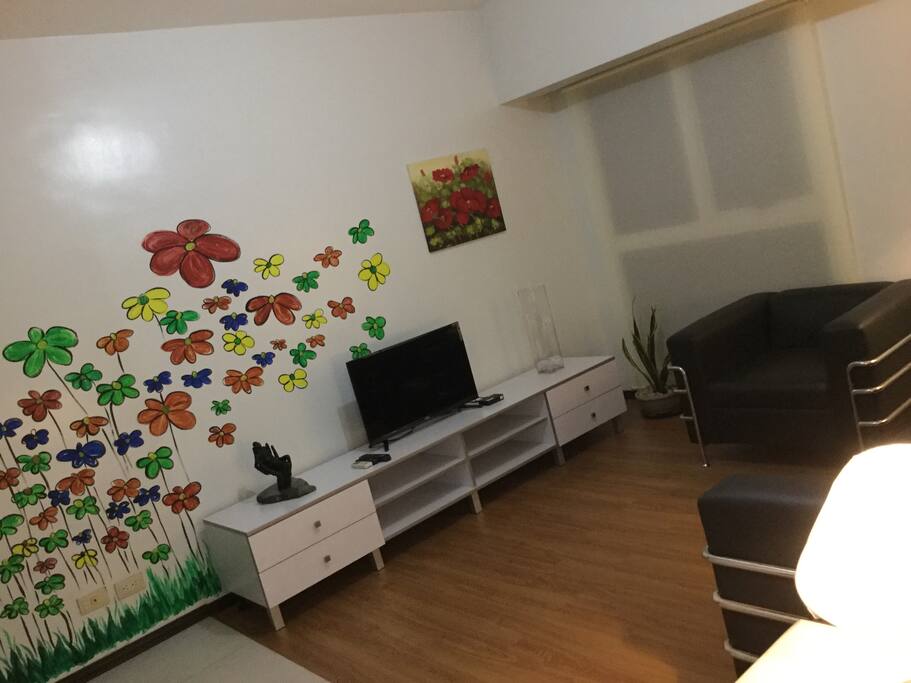 The Living Room. The owner is an artist. The wall painting and the sculpture piece on the console table are some of her works.