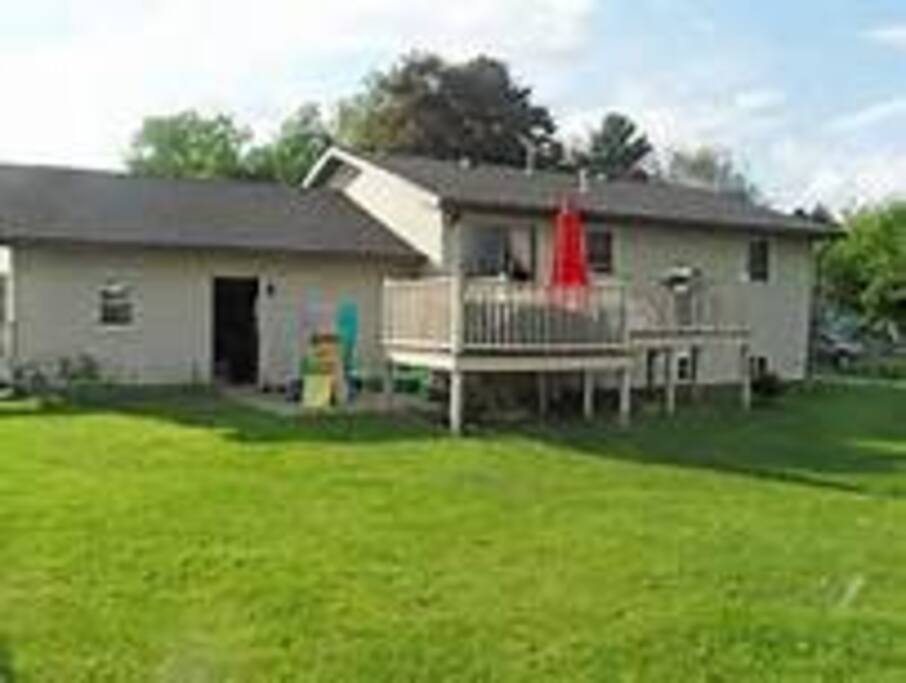Large fenced in backyard with deck