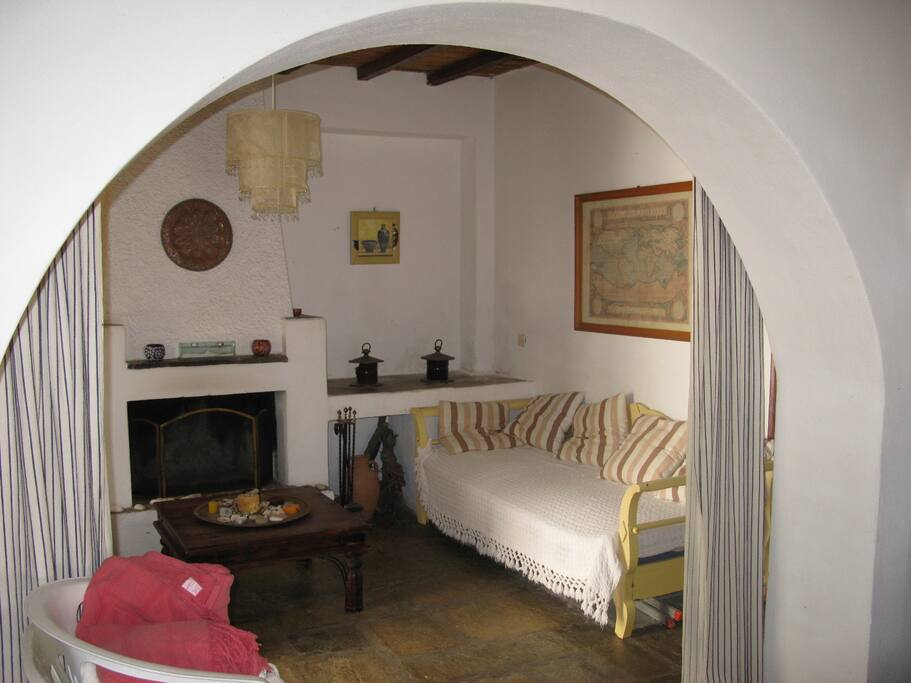 Living room with a hand made traditional couch, which can be used as bed. This place can be separated with discrecy, by closing the curtains of the arch.