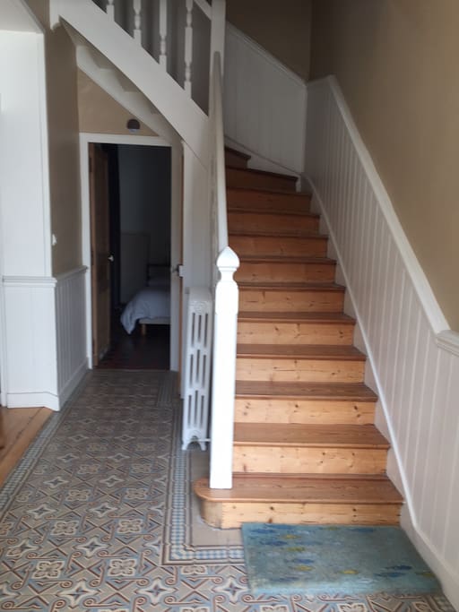 L'entrée avec escalier menant au 1er étage. au fond un chambre pour adultes