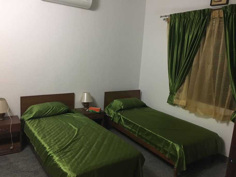The olive room . Two single beds that can be joined ,attached bathroom and a teak wardrobe.the room has both a fan and an air conditioner.