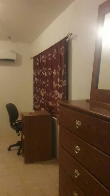one of the bedrooms with drawer and table