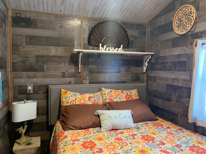 Queen size bed in the separate bedroom of the farmhouse.
