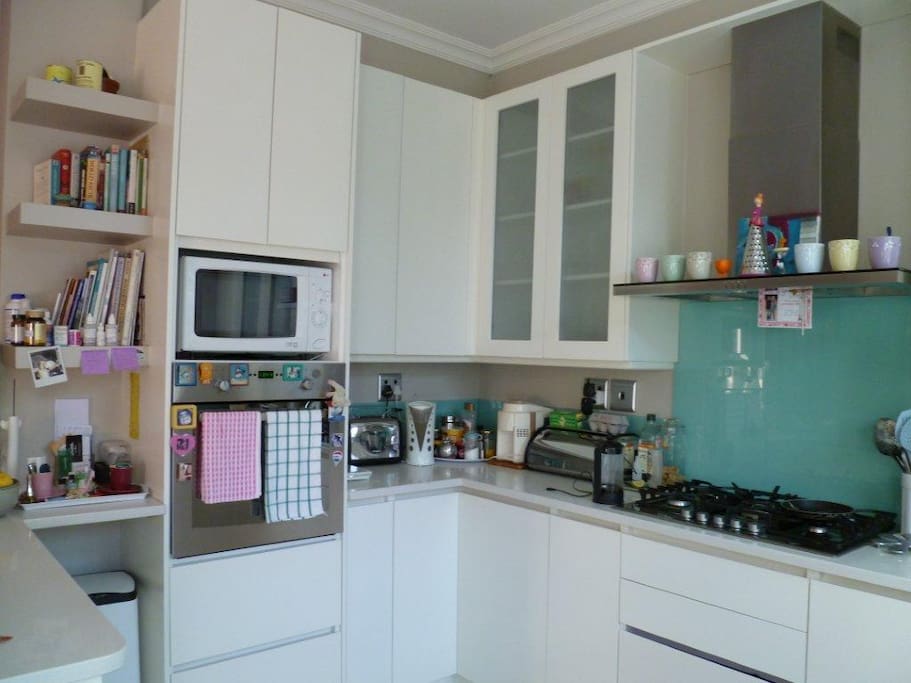 Fitted kitchen with gas hob, oven, microwave, coffee machine and juice extractor