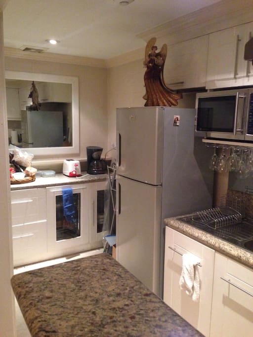 The kitchen features a refrigerator, microwave oven, convection range, sink and drip coffee maker.