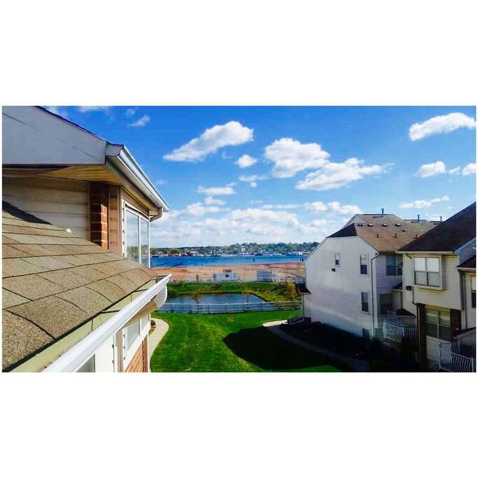 Blue sky, white clouds, ocean bay, Staten Island, and a peaceful pond with ducks