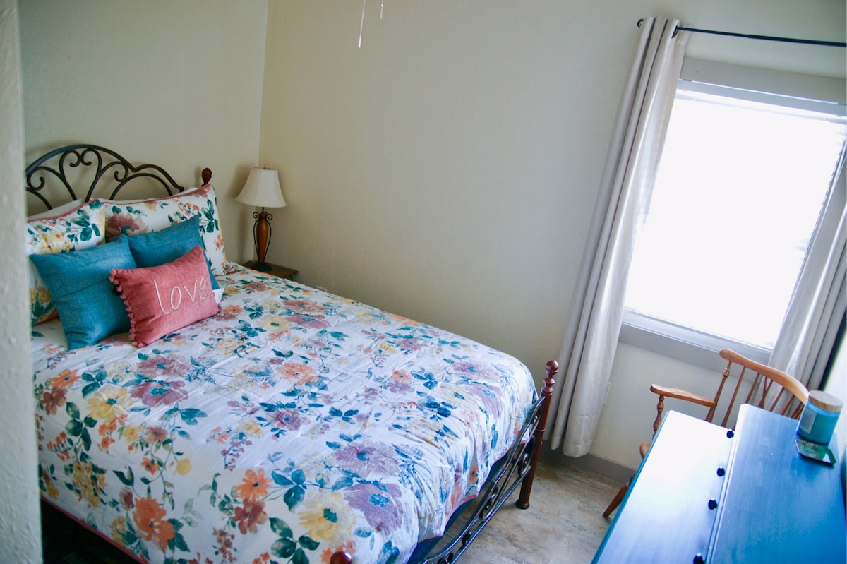 חדר שינה ראשון עם מיטת קווין סייז.