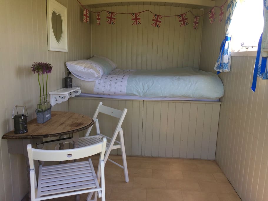 Inside our hut, double bed complete with bedlinen, fold away table and chairs, led lanterns and plenty of storage.