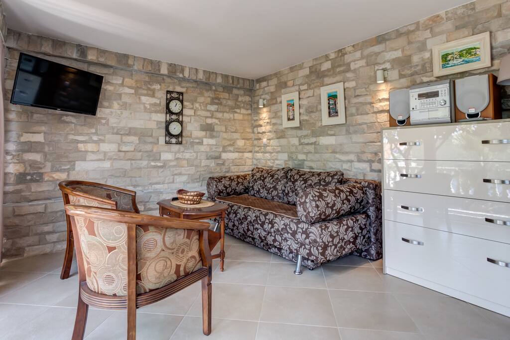 Living room with cosy sofa, TV and stereo