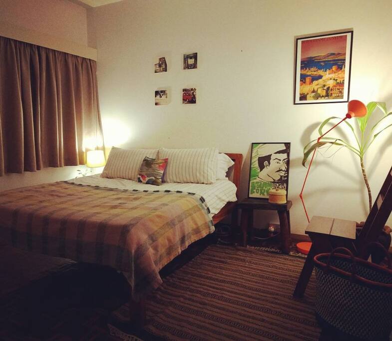 Stylish double bedroom decorated with East African art and crafts, with luxurious en suite bathroom