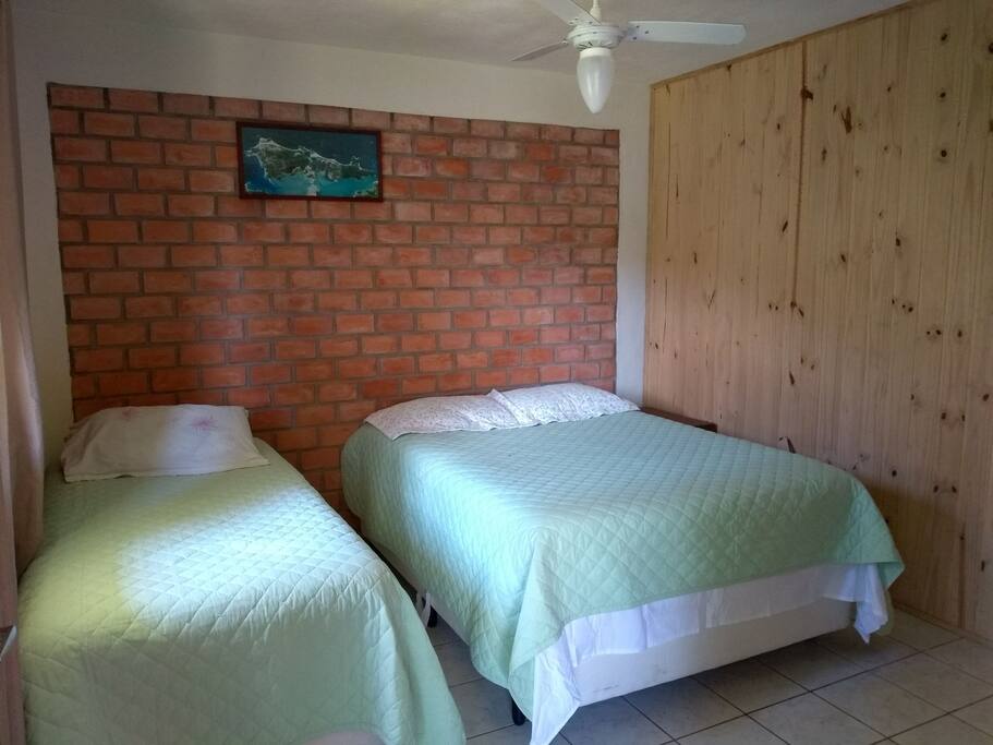 suite com ventilador de teto, cama box de casal e de solteiro.