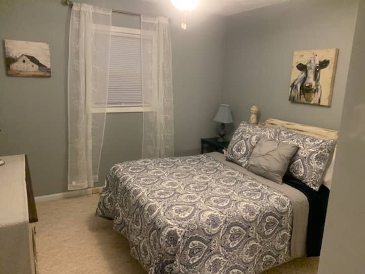 Bedroom - Double - chest of drawers, full closet, a mirror, and a small nightstand with a lamp. 