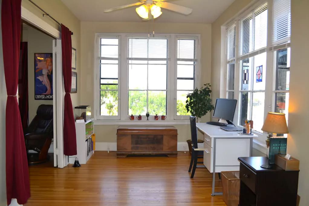 French double doors separate the sunny corner office + front bedroom from the living room.