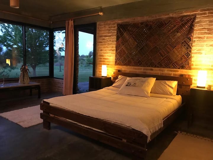 Master bedroom with wood-burning stove and country view.