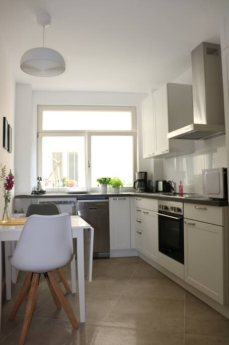 Küche mit Mikrowelle, Geschirrspülmaschine, Herd, Backofen, Kaffeemaschine, Wasserkocher und Toaster
