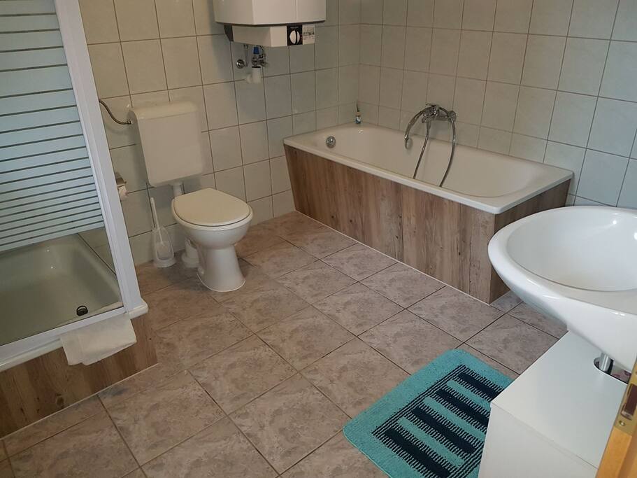 großzügiges Badezimmer mit Badewanne und Dusche