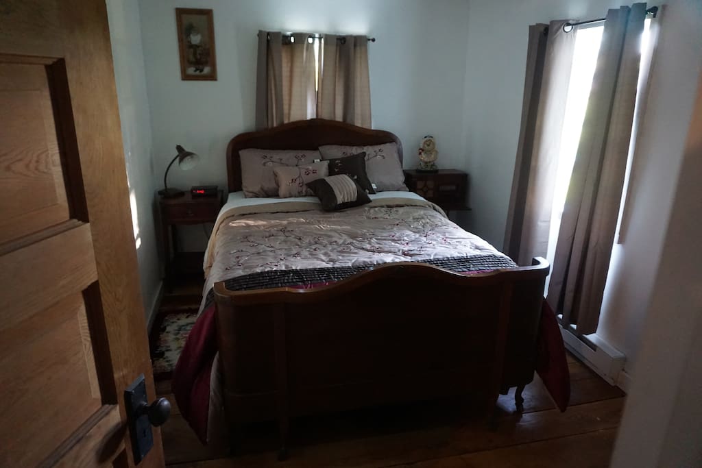 Cozy master bedroom with a full sized bed and dresser.