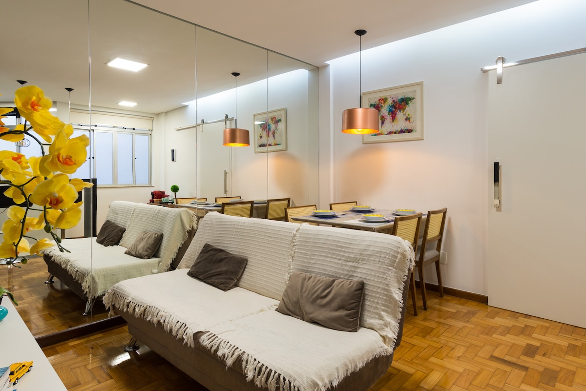 غرفة تلفزيون وطاولة طعام وجدار عاكس