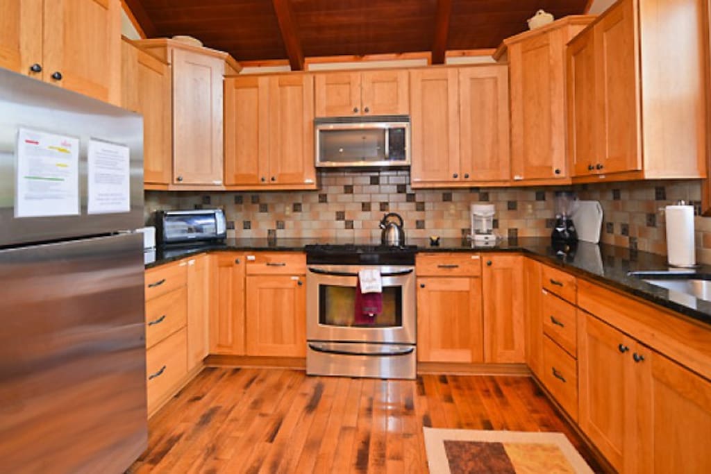 Gourmet kitchen with custom cabinetry andvfully stocked.