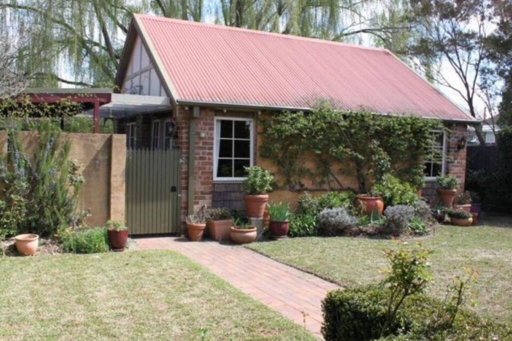 Sunny garden leading to cottage with off-street, undercover parking