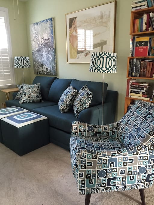 Sitting room with sofa, easy chair and ottomans, in the suite.