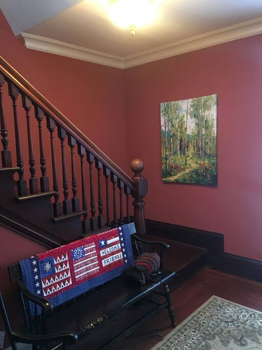 Our entry with small antique love seat for putting on and off your foot ware. As well as the classic round ball newel post staircase.