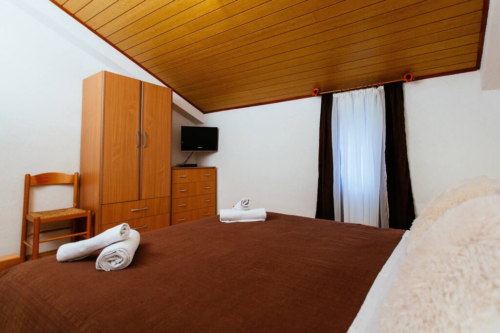 Bedroom overview, LCD SAT/TV, wood panelling and a wardrobe