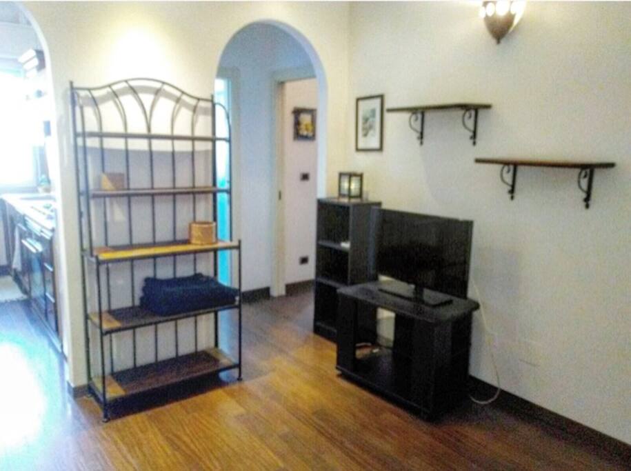 Salotto con TV , etager e divano letto .