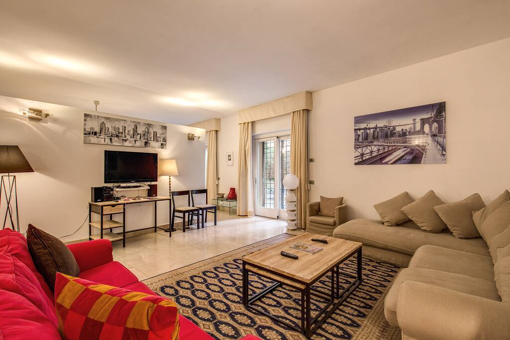 Spacious living room at ground floor with two big comfortable couches, TV, coffee table and access to the shared terrace