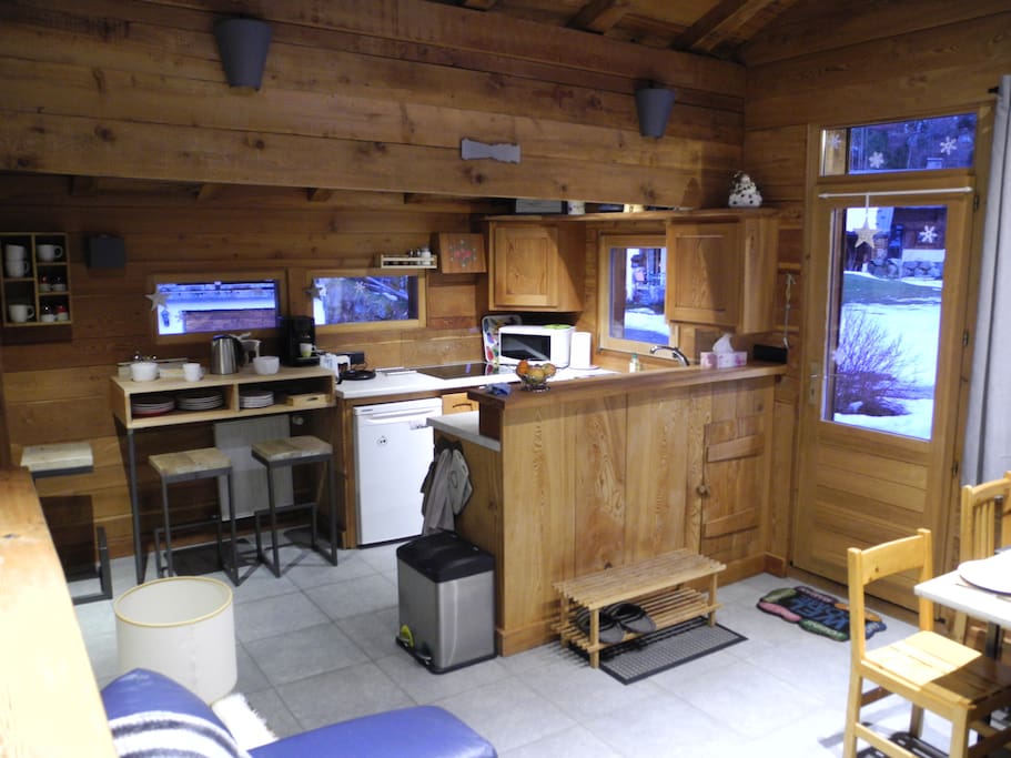 Vue sur la cuisine avec à gauche une table haute pour 3 personnes