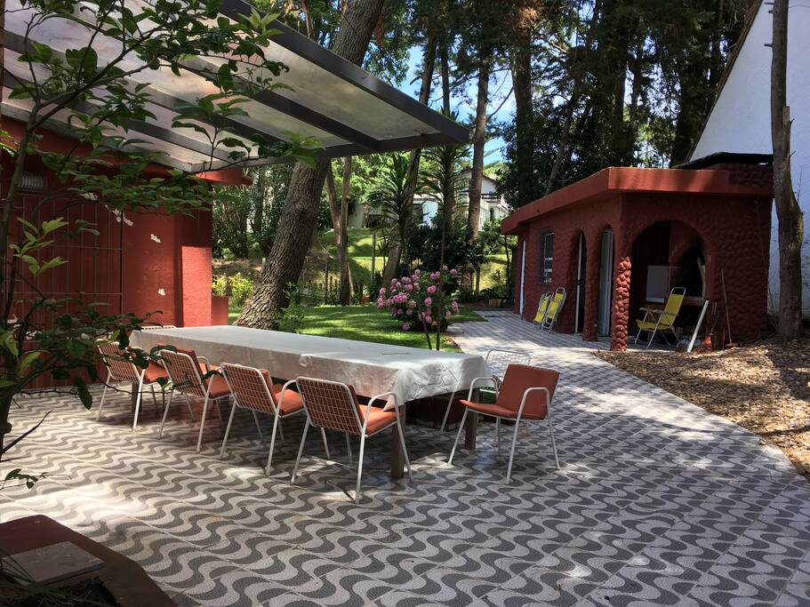 Mesa grande de madera en patio techado, ideal para asados.