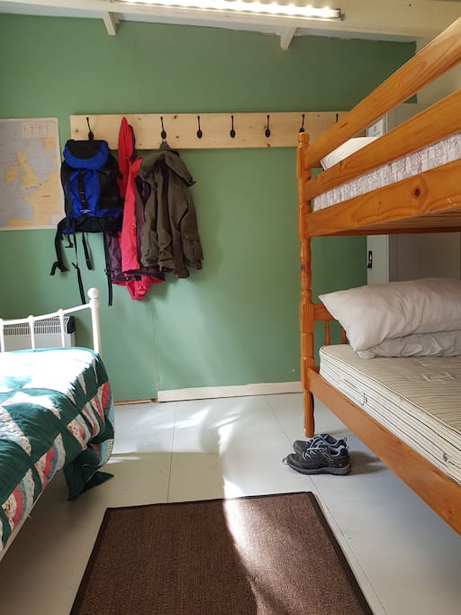 Bunkhouse room 2. Three beds with plenty of hooks for belongings along with locker facilities.