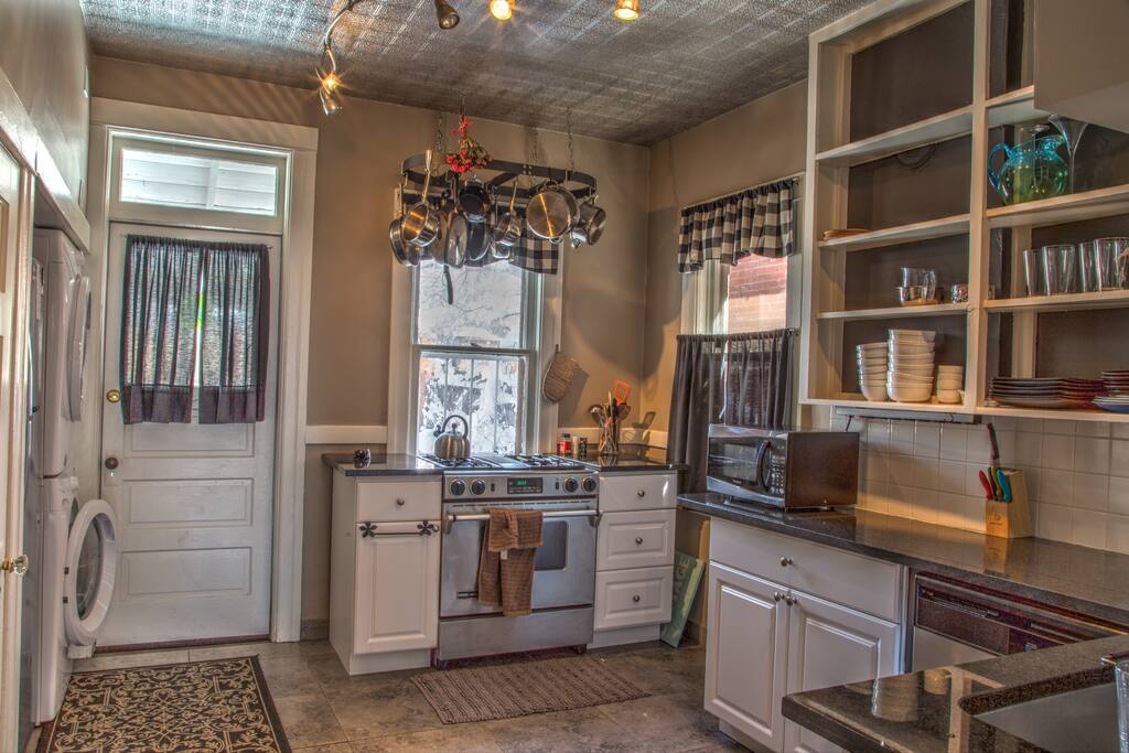 Kitchen with stainless appliances, granite countertops and a washer/drier.