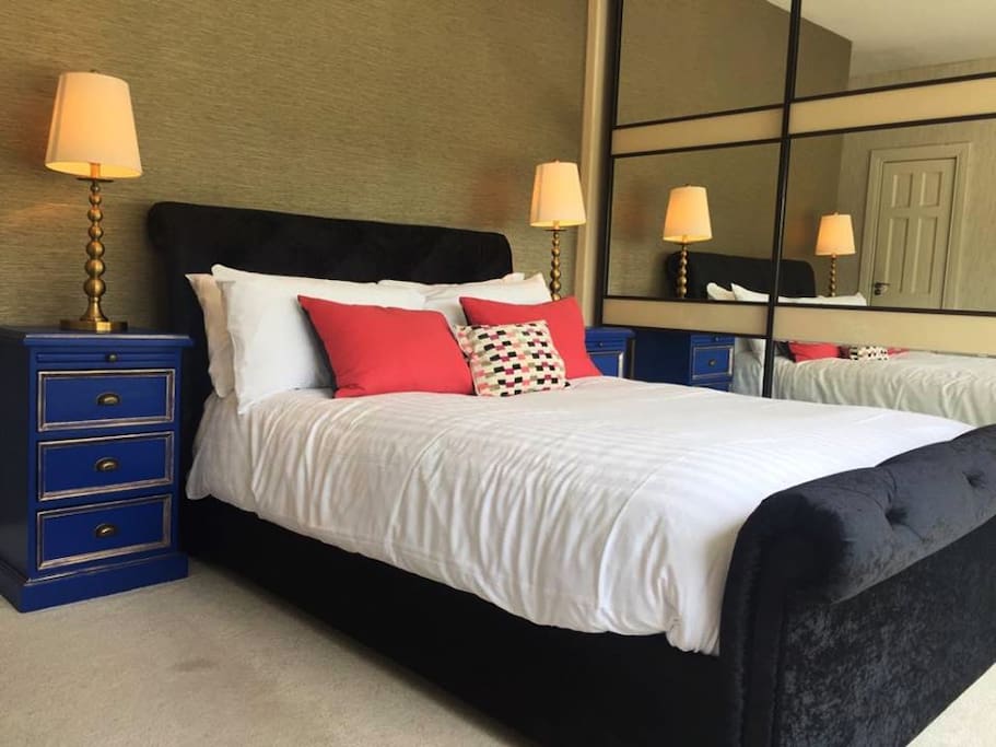 Our King bedroom, with sleek decor, fresh white linens and plenty of natural sunlight