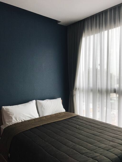 Your bedroom next to big bright floor to ceiling window.