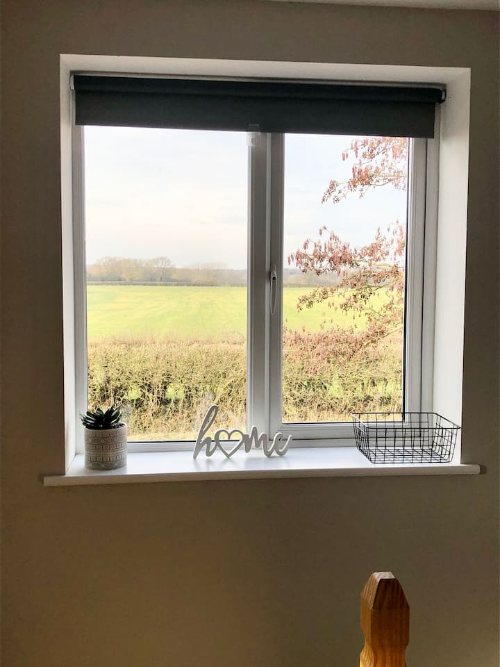 Прекрасен поглед на село низ прозорецот на спалната соба.