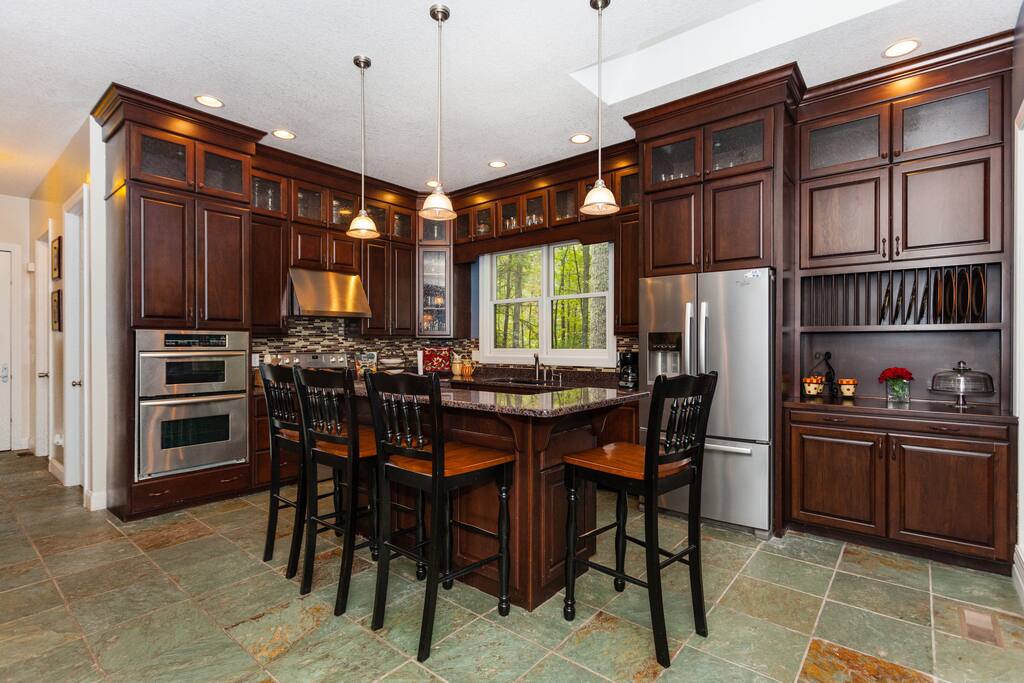 Beautiful kitchen with floor to ceiling cabinets granite countertops and dual ovens.