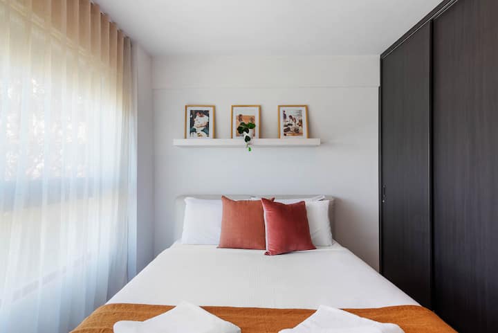 The first light-filled queen bedroom is beautifully styled and features hotel quality linens for a good night's sleep. 