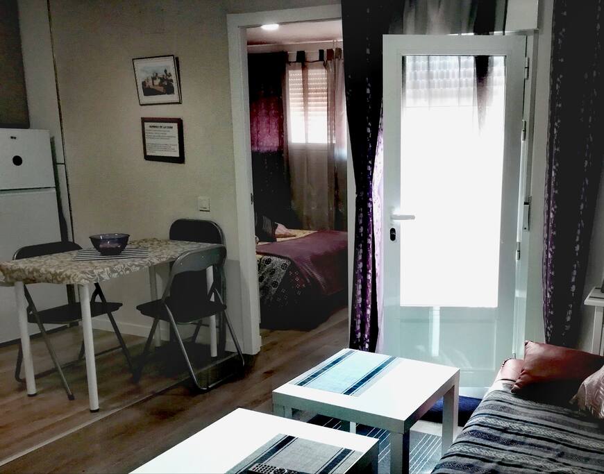 habitación con cama de matrimonio, salón con sofá cama y la cocina americana.