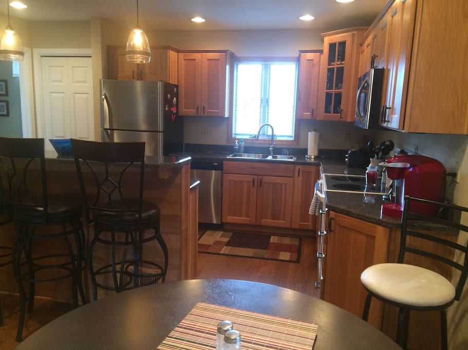 Kitchen remodeled a few years ago with new eating bar, birch wood cabinets, sink/faucet, refrigerator, microwave and counters.