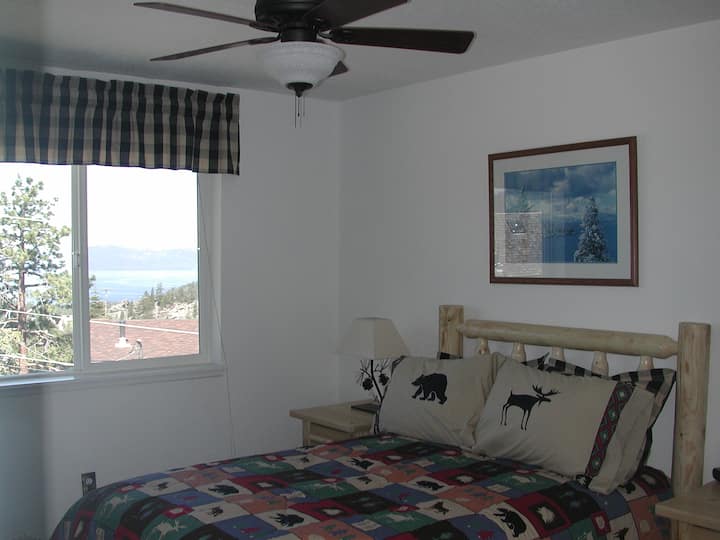 Spavaća soba s bračnim krevetom i pogledom na jezero te TV-om