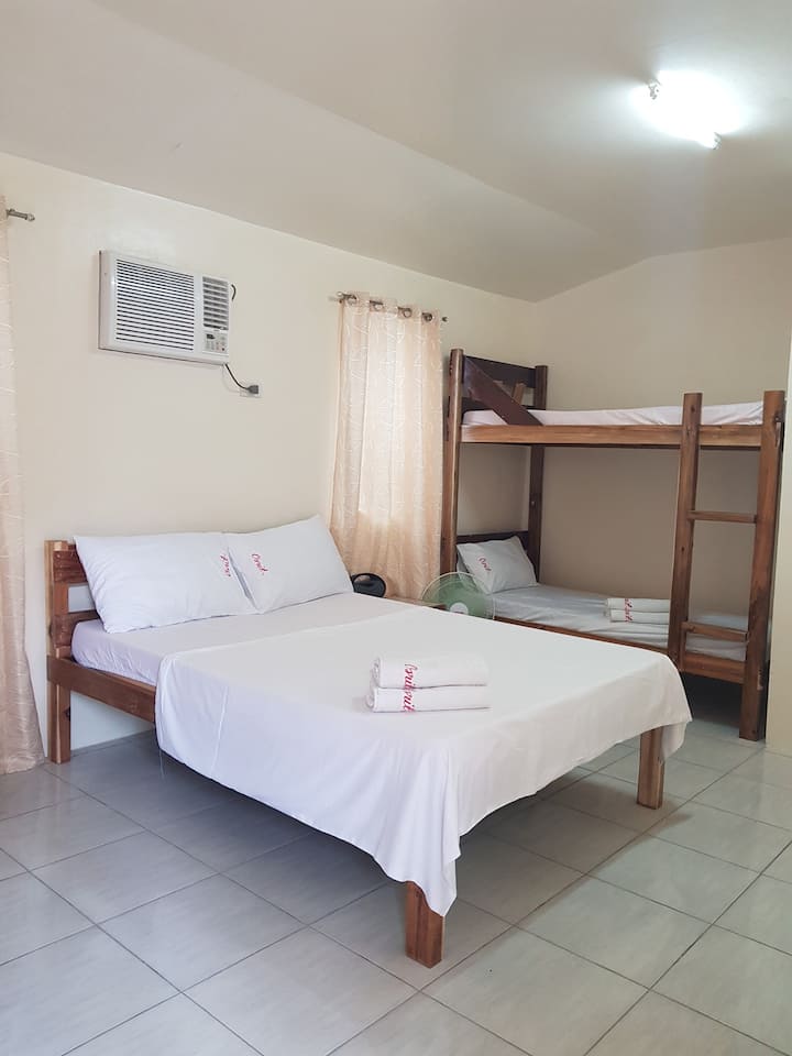 a private room with a bunk bed  and a queen size bed  ideal for travelling firends . can accommodate 4 peaople and has a private comfort room. well air conditioned rooms and a veranda you can use for small talks or even enkoy the wifi.