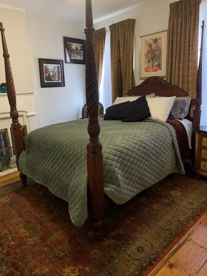 Quarto principal com cama queen, no segundo andar, de frente para a praça principal.