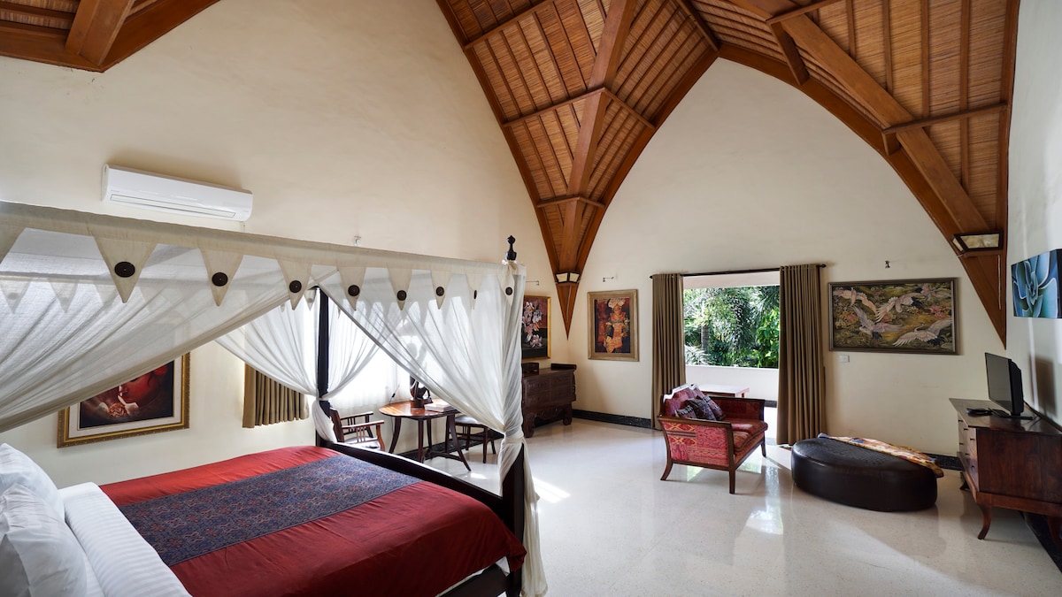 宽敞的卧室，配有拱形天花板和四柱床。