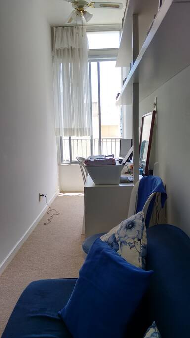 Sala com dois ambientes, sofá cama, ventiladores e ar condicionado