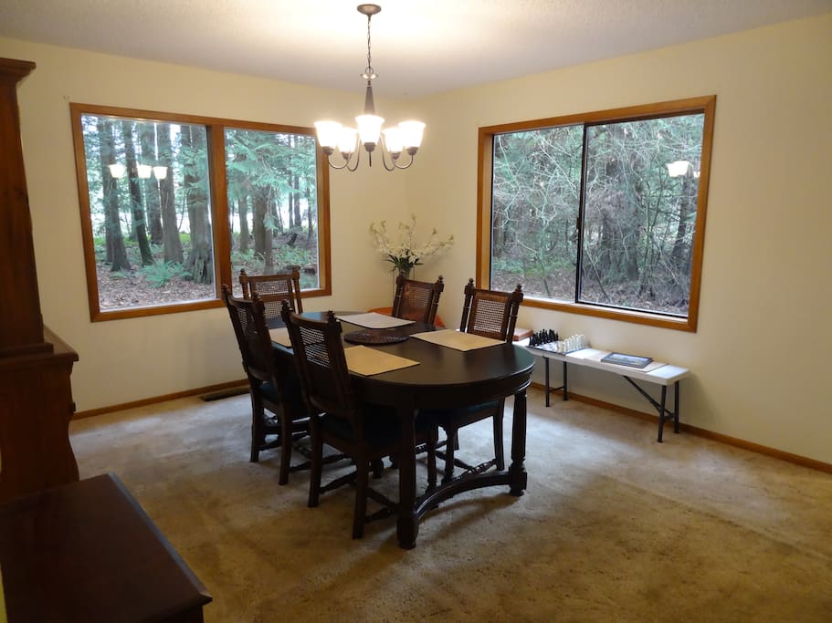 Dinning room with picture windows looking into forested surroundings.