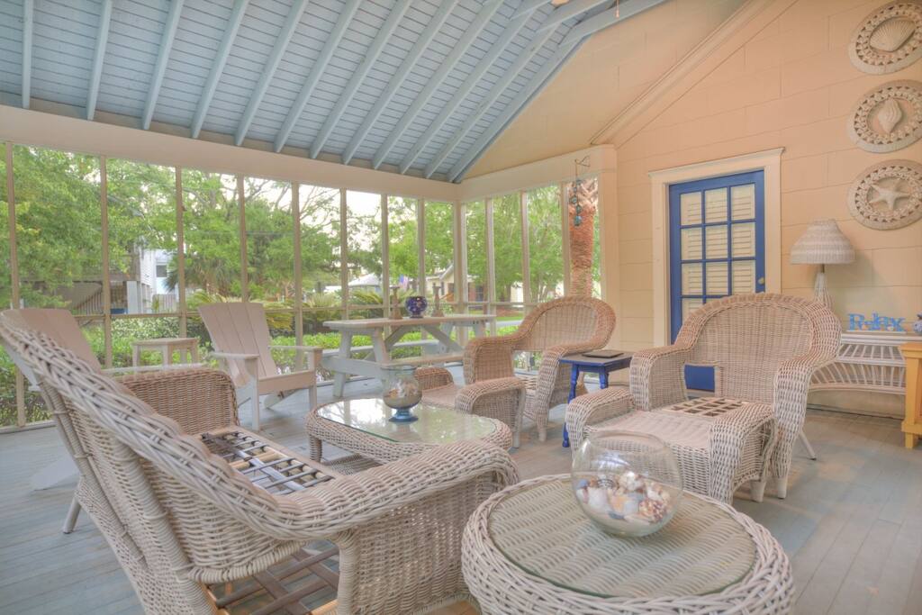 Large screened outdoor living room with comfortable seating for the whole guest list