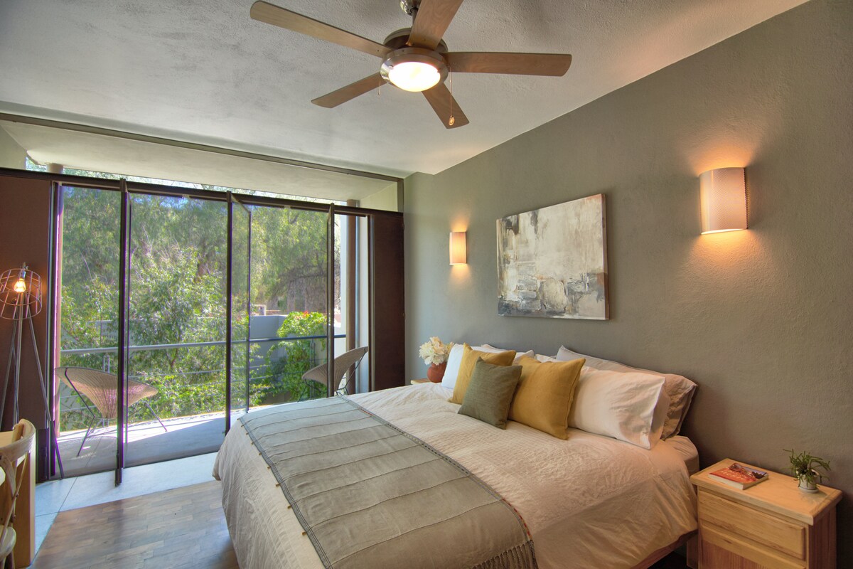 El dormitorio principal, con cama king, vistas a la copa del árbol, toneladas de almacenamiento y una televisión.