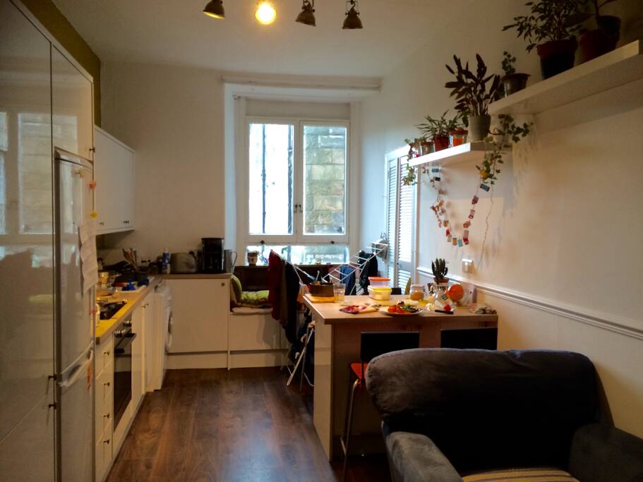 large kitchen/sitting area with sofa, armchair and TV